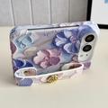 iPhone Duo -kotelo, jossa on kohokuvioitu vesivärikukkakuvio ja rannehihna - sininen